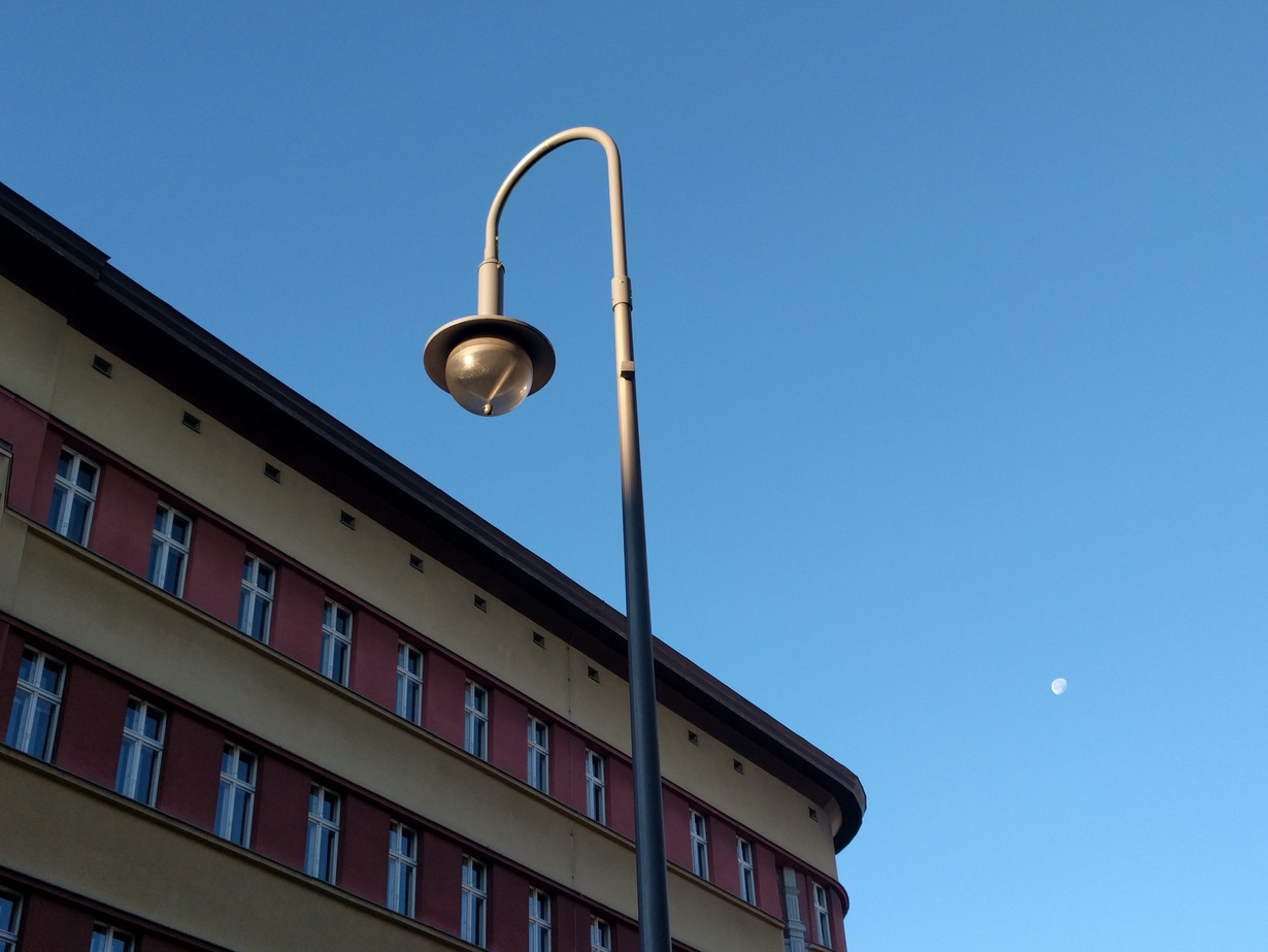 Hintergrundbild: Eine Straßenlaterne vor dem Hintergrund des „TAB-Gebäudes“ in der Neuen Schönhauser Str. 10.