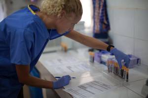 Hintergrundbild: Eine Frau im Labor begutachtet Proben (TAB-Projektbild: Medizinische Innovationen für Afrika)