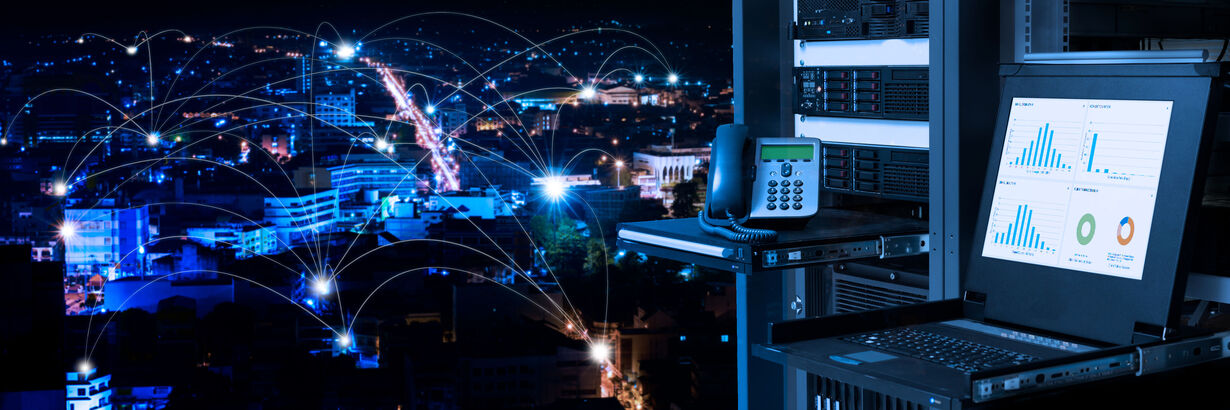 Blick auf erleuchtete Stadt in der Nacht aus der Perspektive einer Telefonzelle mit Recher