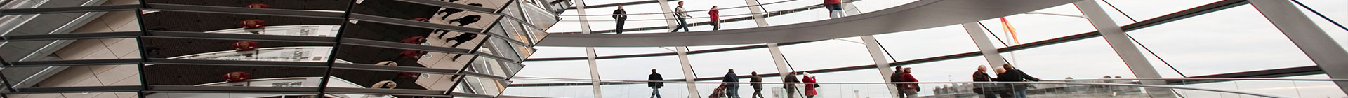 Blick in die Kuppel des Reichstagsgebäudes mit Personen unterschiedlichen Alters, die in der Spiegesäule reflektieren